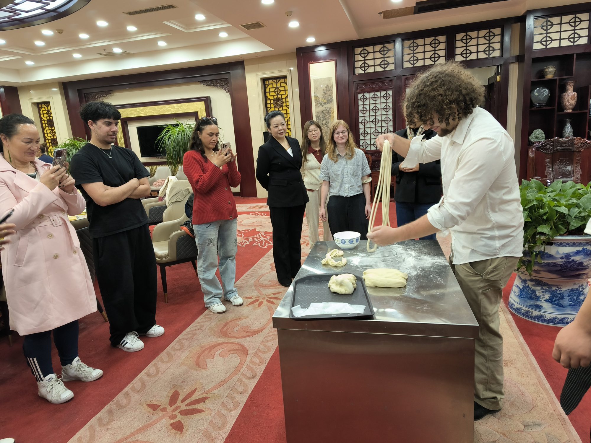 Volunteers watching a chef demonstrate hand-pulled noodles in Jiangxi