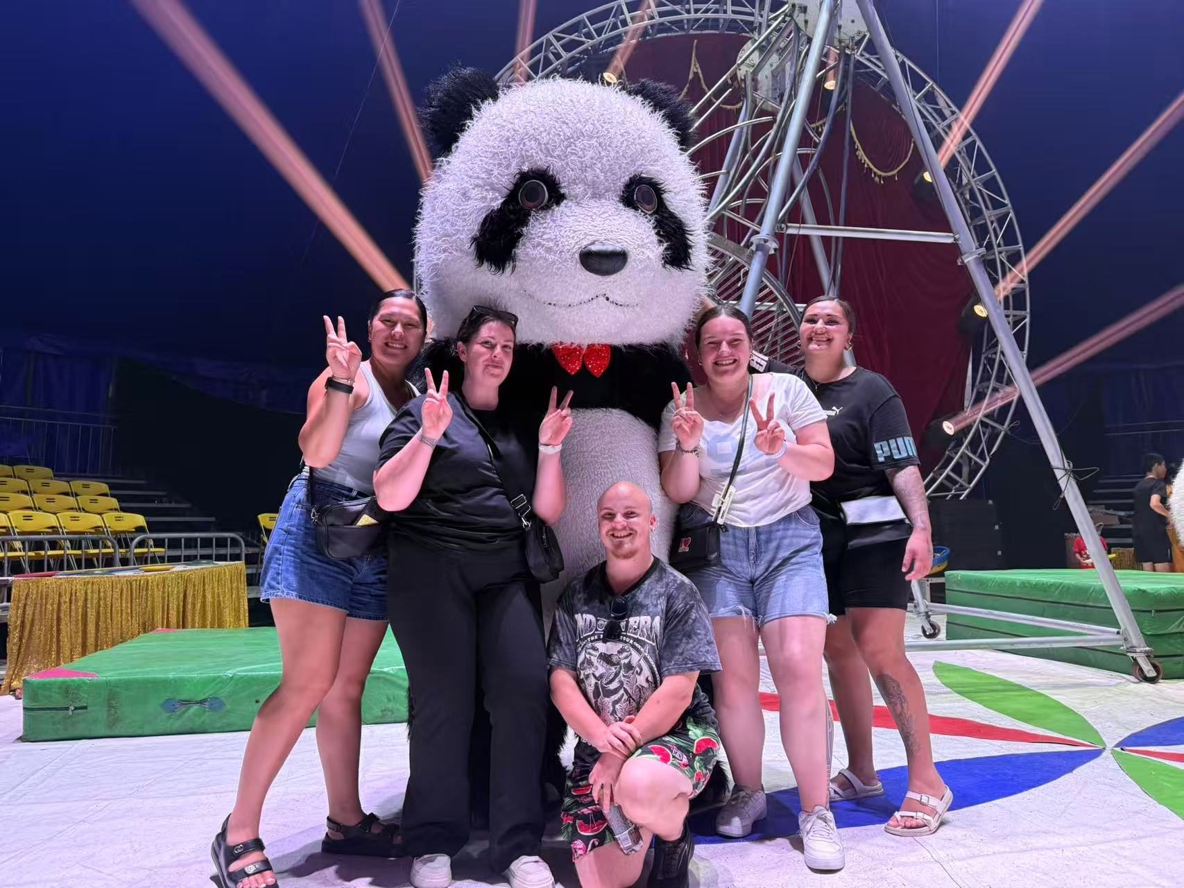Volunteers posing with a giant panda mascot at a local festival
